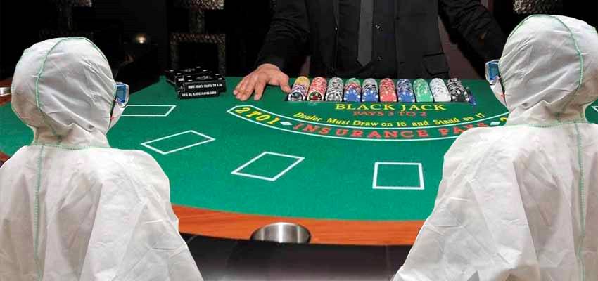 two people in hazmat suits playing at a blackjack table